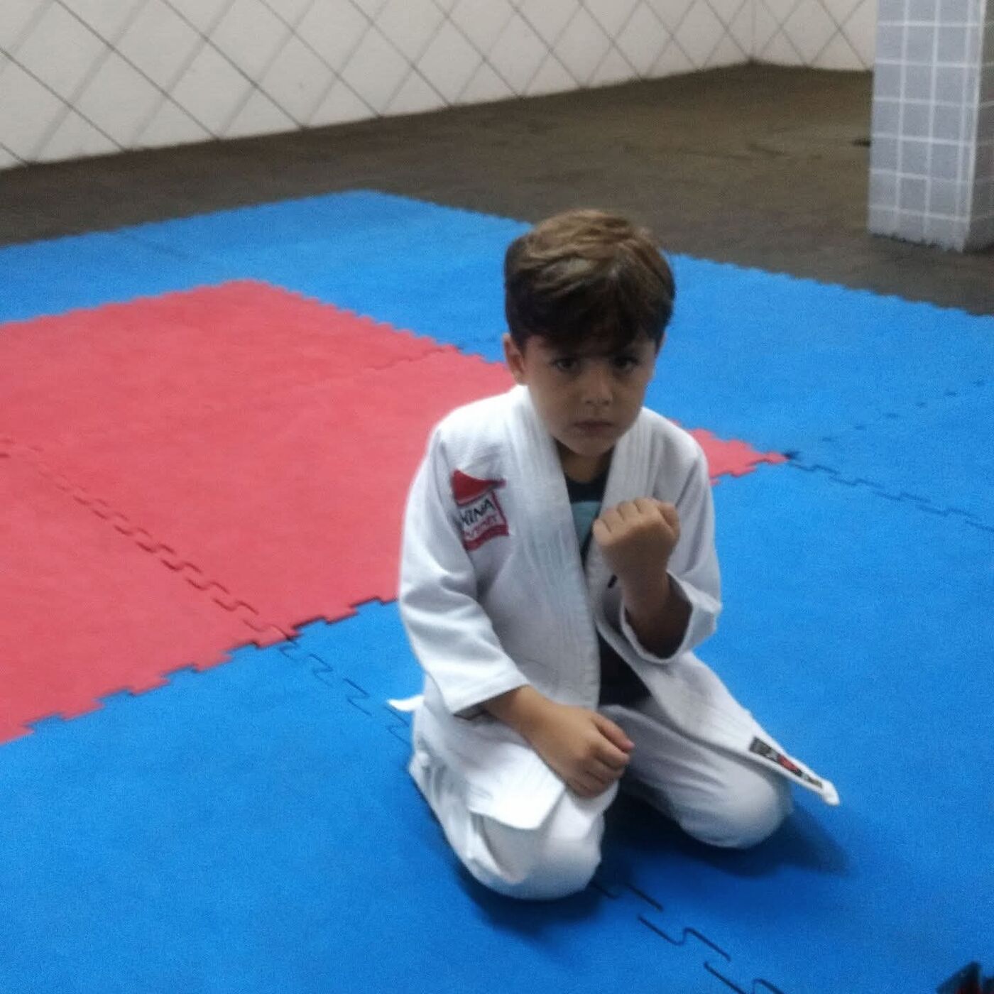 Guilherme criança, de quimono branco, no tatame